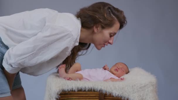 Cerca de la madre besa suavemente al bebé disfrutando de una madre cariñosa cuidando juguetonamente al niño pequeño compartiendo la conexión con su bebé recién nacido cuidado infantil saludable . — Vídeo de stock