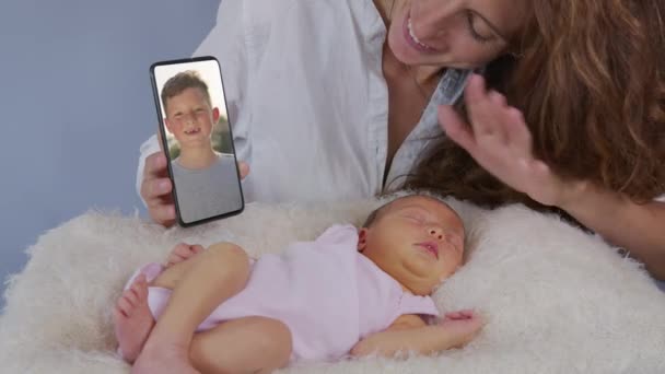 Joven madre y bebé teniendo video chat. mujer usando teléfono inteligente saludando a su hija pequeña disfrutando de la conexión familiar . — Vídeo de stock