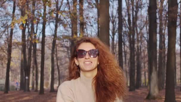 Ragazza gettando fogliame colorato autunno in aria nel parco. — Video Stock