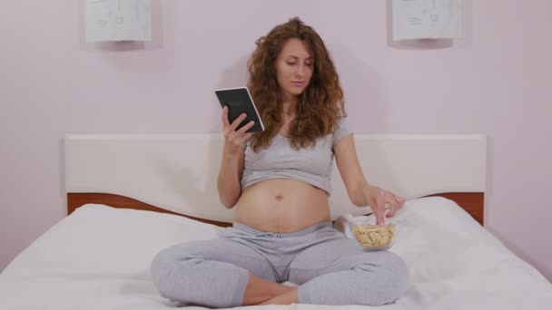 Woma viendo la televisión comer bocadillo disfrutar de la sala de televisión en el sofá divertirse en la sala de estar en casa . — Vídeos de Stock