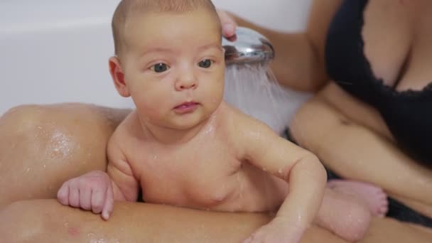 Bébé nouveau-né drôle pendant le bain avec la mère. — Video