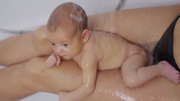 Bébé nouveau-né drôle pendant le bain avec la mère. — Video