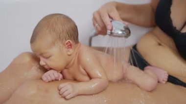 Yeni doğmuş bebek evde banyoda banyo yapıyor. Yeni doğan bebek için hijyen ve sağlık hizmeti.