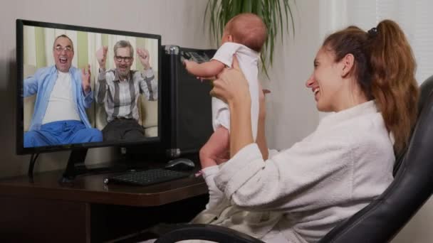 Mutter und Baby unterhalten sich per Smartphone mit dem Großvater und winken dem Neugeborenen zu, das Familienanschluss genießt. — Stockvideo