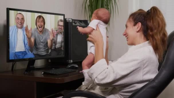 Mutter und Baby unterhalten sich per Smartphone mit dem Großvater und winken dem Neugeborenen zu, das Familienanschluss genießt. — Stockvideo