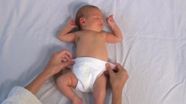 Anne yeni doğmuş bebeğinin altını değiştiriyor..