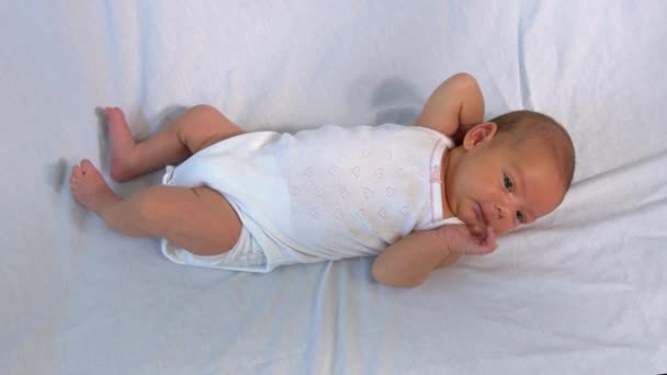 Kleines Neugeborenes liegt auf weißem Boden. — Stockvideo