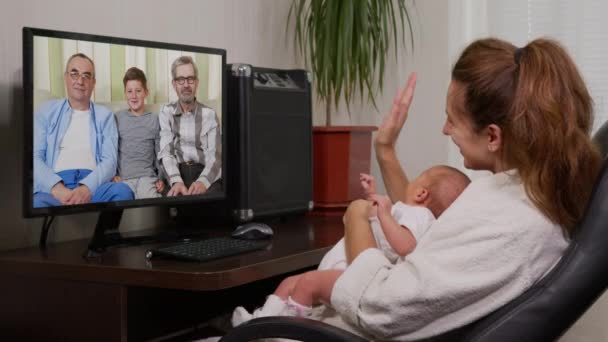 Mamma och barn som har videochatt med morfar med hjälp av smartphone vinka åt nyfödda spädbarn njuter av familj anslutning. — Stockvideo