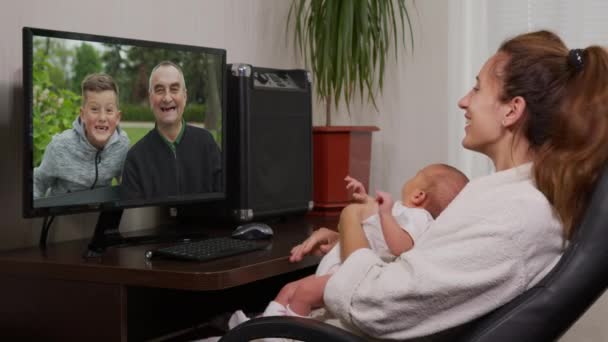 Madre y bebé teniendo video chat con el abuelo PC saludando al recién nacido disfrutando de la conexión familiar . — Vídeos de Stock