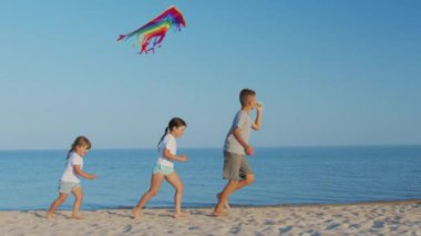 Mutlu bir çocuk kumsalda uçurtma oynuyor. Yaz tatili.