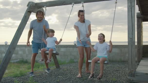 Bonne famille sur une balançoire à la lumière du soleil. Concept de famille heureuse. — Video