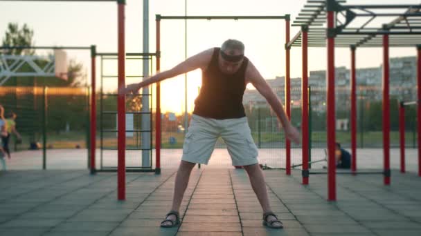 Starszy biały mężczyzna robi ćwiczenia fitness po pandemii wirusa koronawirusa w parku. Ćwiczenia dla starszych ludzi. Stary, wysportowany dziadek. Motywacja sportowa dla emerytów. — Wideo stockowe