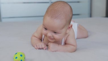 Gülümseyen güzel bebek, gülümseyen oyuncak ve tükürüyor..