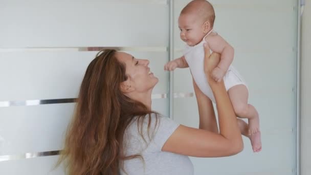 Primer plano madre besos feliz bebé riendo disfrutando amoroso mamá nutrir niño en casa. — Vídeos de Stock