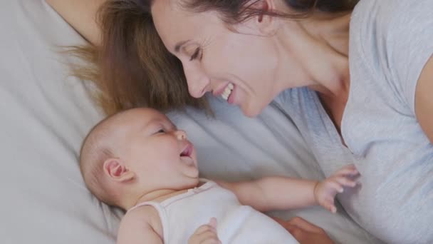 Närbild mamma kysser glad baby skrattar njuter kärleksfull mamma vårda barn hemma. — Stockvideo