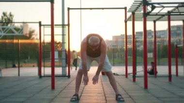 Yaşlılar sağlıklı bir yaşam tarzı. Çocuk parkında koronavirüs virüsü salgınından sonra spor yapan yaşlı beyaz bir adam. Son sınıflar için antrenman. Atletik yaşlı büyükbaba.