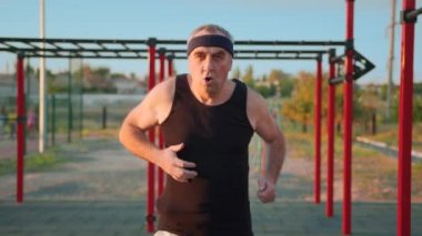 Yaşlılar sağlıklı bir yaşam tarzı. Çocuk parkında koronavirüs virüsü salgınından sonra spor yapan yaşlı beyaz bir adam. Son sınıflar için antrenman. Atletik yaşlı büyükbaba.