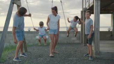Büyük neşeli aile salıncakta eğleniyor..