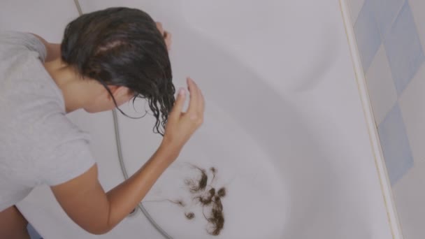 Problemy z włosami. Włosy dziewczyn wypadają do łazienki podczas mycia. — Wideo stockowe