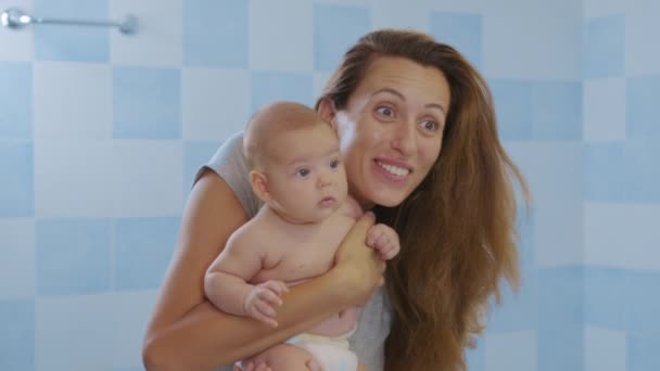 Houden van tedere jonge moeder met schattige schattige kleine meisje dochter omarmen zoenen kleine kind. Gelukkige liefhebbende moeder knuffelen met baby kind, staan thuis. — Stockvideo