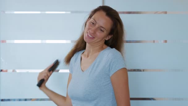 女人用刷子刷头发，担心头发脱落或状况不佳。烦躁的女人脱发. — 图库视频影像