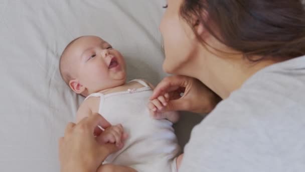 Close-up shot van jonge moeder speelt met haar pasgeboren baby in een kinderkamer in een ochtend. Concept van kinderen, baby, ouderschap, jeugd, leven, moederschap. — Stockvideo