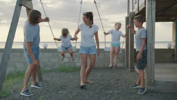 Família feliz em um balanço na luz do sol. Conceito de família feliz. — Vídeo de Stock