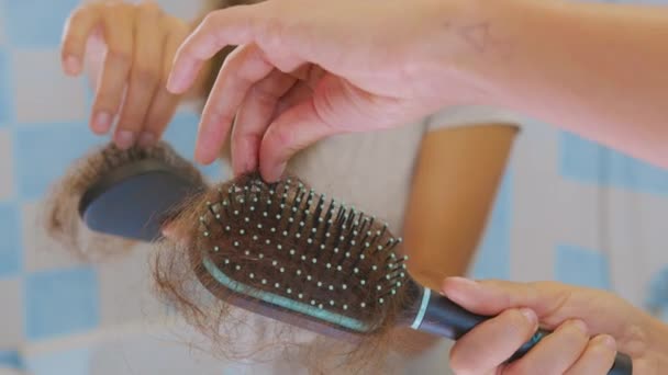 Mani femminili pulite. Un sacco di capelli caduti su un pettine. Problema di perdita dei capelli, insufficienza ormonale, stress, dieta, cuoio capelluto e malattia del bulbo pilifero. — Video Stock