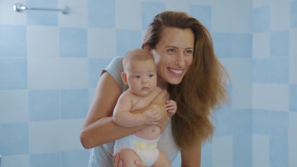 Houden van tedere jonge moeder met schattige schattige kleine meisje dochter omarmen zoenen kleine kind. Gelukkige liefhebbende moeder knuffelen met baby kind, staan thuis. — Stockvideo