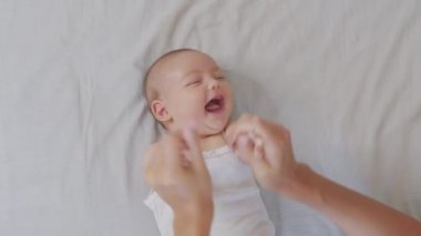 Genç annenin yakın plan çekimi, yeni doğmuş bebeğiyle bir sabah kreşte oynayacak. Çocuk, bebek, ebeveynlik, çocukluk, hayat, annelik kavramı.