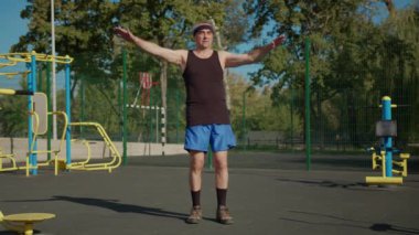 Aktif kıdemli, yaşlı, beyaz bir adam spor alanında fiziksel egzersiz yapıyor. Fitness eğlencesi. Yaşlılıkta sağlıklı yaşam tarzı.