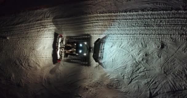 Letecký pohled. Snow Grooming Snowcat Machines Fix Trail on Ski Resort Slope at Night. — Stock video