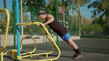 Emekli yaşlı bir adam dışarıda spor salonunda çalışıyor. Sağlıklı yaşam tarzı kavramı.