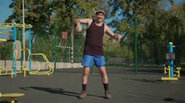 Aktif kıdemli, yaşlı, beyaz bir adam spor alanında fiziksel egzersiz yapıyor. Fitness eğlencesi. Yaşlılıkta sağlıklı yaşam tarzı.