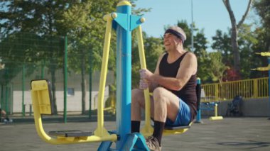 Emekli yaşlı bir adam dışarıda spor salonunda çalışıyor. Sağlıklı yaşam tarzı kavramı.