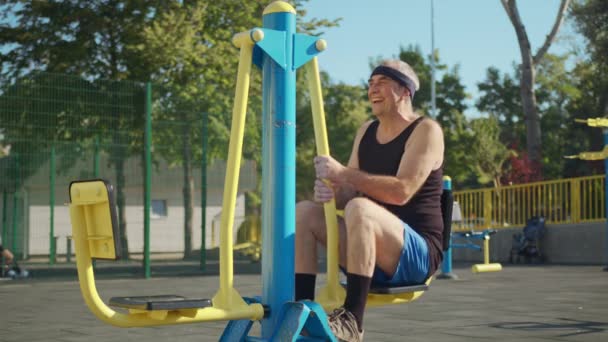 Un anciano retirado hace ejercicio en un campo de deportes afuera. concepto de estilo de vida saludable. — Vídeos de Stock