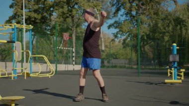 Yaşlı bir adam dışarıda ısınıyor..