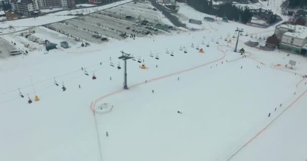 Luftaufnahme: Skigebiet, Piste und Sessellift. Eine Seilbahn bringt die Skifahrer auf den Berg. Winteraktivität. — Stockvideo