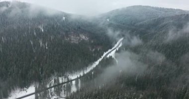 Hava görüntüsü. Kış günü manzaralı dağ manzarası, alçak bölgelerde sis..
