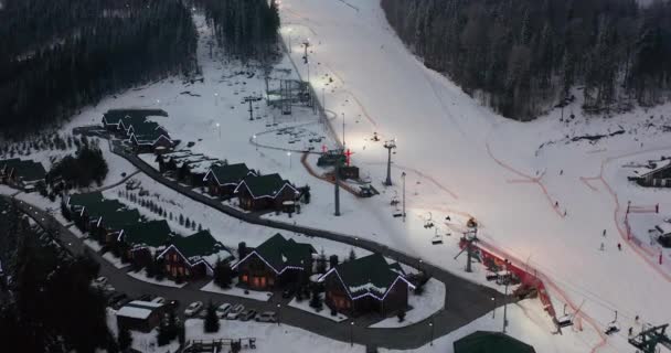 Luftaufnahme: Skigebiet, Piste und Sessellift. Eine Seilbahn bringt die Skifahrer auf den Berg. Winteraktivität. — Stockvideo