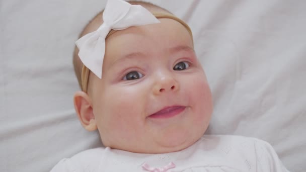 Newborn baby girl, Care and Love, Portrait of a Child. Happy baby at the age of three months lies in the crib and smiles. — Stock Video