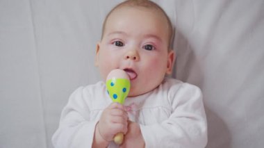 Sevimli küçük bebek yatakta oyuncak oynuyor..