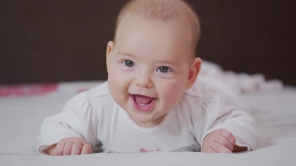 Hezké malé bělošské děťátko se směje. Portrét hravého a energického dítěte zblízka. — Stock video