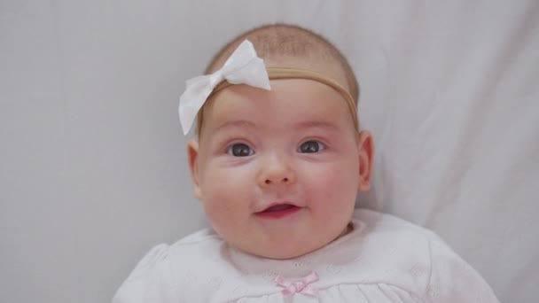 Nowonarodzona dziewczynka, Pielęgnacja i Miłość, Portret dziecka. Szczęśliwe dziecko w wieku trzech miesięcy leży w łóżeczku i uśmiecha się. — Wideo stockowe
