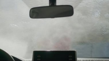 Konveyör tünel oto yıkama yerindeki arabanın içini kapat. Araba sabun ve suyla yıkanır..