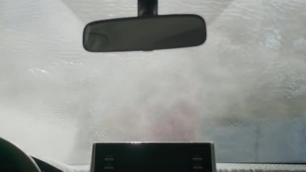 Vista de perto de dentro do carro em lavagem de carro de túnel transportador. Lavagem de carro com água e sabão. — Vídeo de Stock