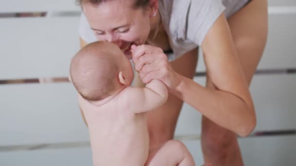 Young mother holding her newborn child. Mother breast feeding baby. Family at home. — Stock Video