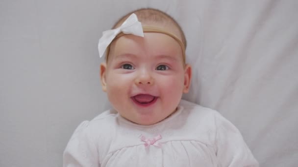 Nowonarodzona dziewczynka, Pielęgnacja i Miłość, Portret dziecka. Szczęśliwe dziecko w wieku trzech miesięcy leży w łóżeczku i uśmiecha się. — Wideo stockowe
