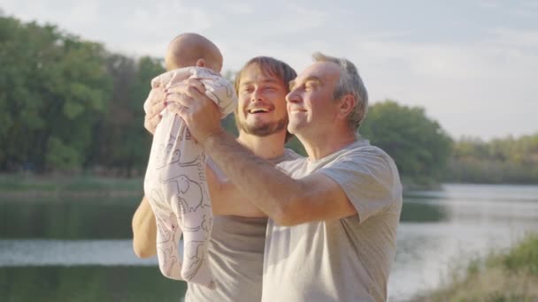 Grootvader die baby 's buiten in de armen houdt. Grootouder binding met kleinkind. — Stockvideo