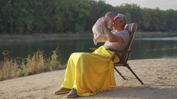 Abuelo sosteniendo bebé recién nacido nieta al aire libre. — Vídeos de Stock